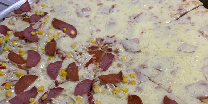 Pizza con dos sabores: una mitad de peperoni con maíz tierno y la otra de jamón con queso