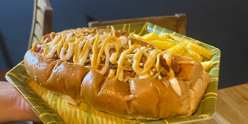 Perro caliente con papas ripio y salsas, servido con papas a la francesa